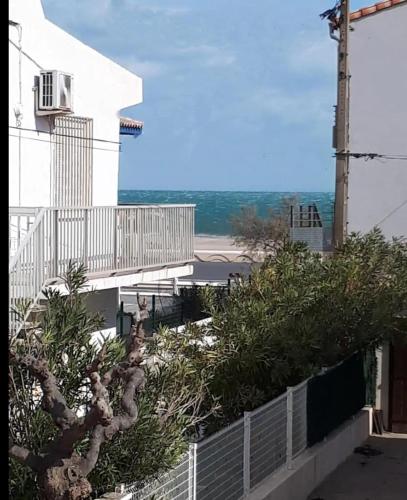 - une vue sur un bâtiment avec un palmier dans l'établissement Direction Sud !, à Narbonne-Plage