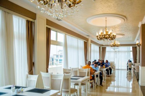 a group of people sitting at tables in a restaurant at Capitol Hotel in Baku