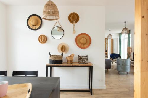 une salle à manger avec des chapeaux sur le mur dans l'établissement Appartement - Le Miln, à Carnac