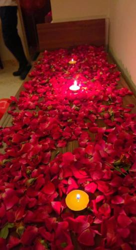 a bunch of red roses with a candle in the middle at Mauji's Villa Hotel & Guest House in Prayagraj