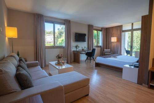uma grande sala de estar com um sofá e uma cama em Hotel Golden Barcelona em Vallromanes