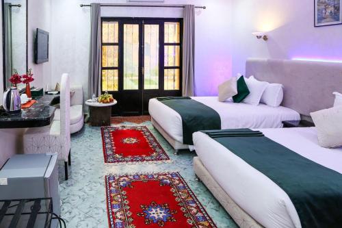 pokój hotelowy z 2 łóżkami i stołem w obiekcie Erfoud Palace w mieście Arfud