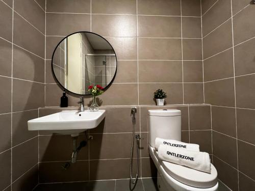a bathroom with a sink and a toilet and a mirror at D'pristine by Antlerzone in Johor Bahru
