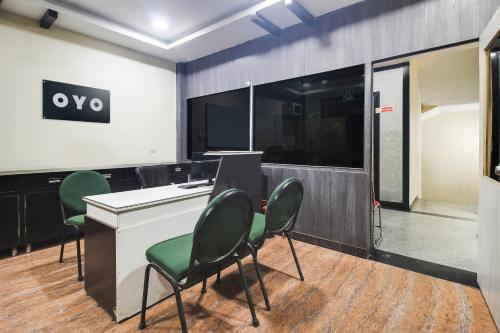 an office with green chairs and a desk with a tv at Super OYO Anuguna Tulasi Grand Near JNTU University Hyderabad in Kukatpalli