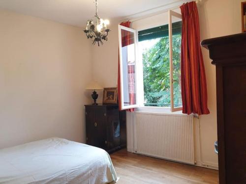 Schlafzimmer mit einem Bett und einem Fenster in der Unterkunft Maison jardin porte de paris in Vitry-sur-Seine