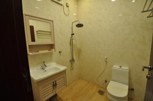 a bathroom with a toilet and a sink and a mirror at Fakher Yanbu 3 Furnished Units in Yanbu