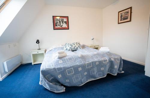 a bedroom with a bed with a blue carpet at Frederiksværk Hotel in Frederiksværk