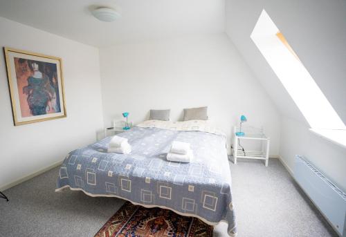 a bedroom with a bed with a blue comforter at Frederiksværk Hotel in Frederiksværk