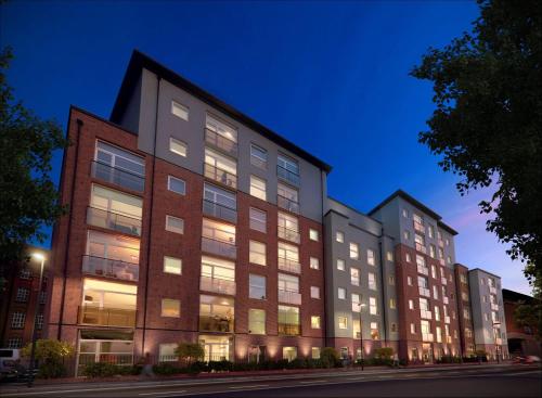 a large building with many windows at night at Rent Luxuri - Luxury 2 bed Apartment in Leicester