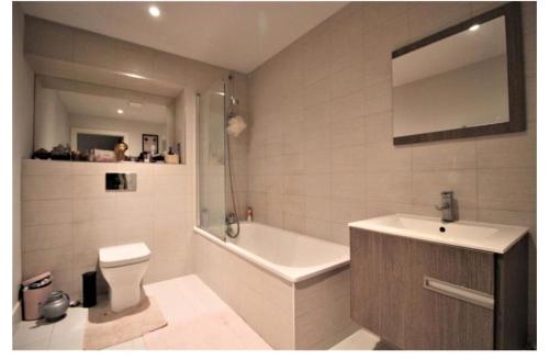 a bathroom with a tub and a toilet and a sink at Rent Luxuri - Luxury 2 bed Apartment in Leicester