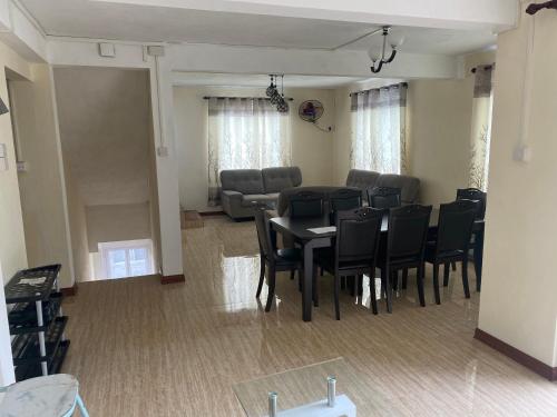 une salle à manger avec une table, des chaises et un canapé dans l'établissement Vue sur mer, à La Gaulette