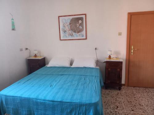 a bedroom with a blue bed and two night stands at Casa di Adele con giardino privato a 150 mt dal mare in Senigallia