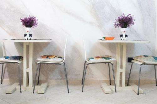 dos mesas y taburetes con flores encima en ALTROVE b&b en Acquaviva delle Fonti