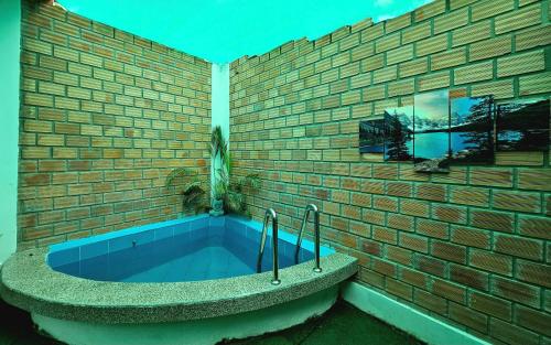 uma parede de tijolos com uma banheira azul em frente a um edifício em MORALES BUNGALOWS em Tarapoto