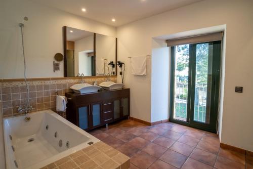 a bathroom with a tub and a large mirror at Hotel Golden Barcelona in Vallromanes