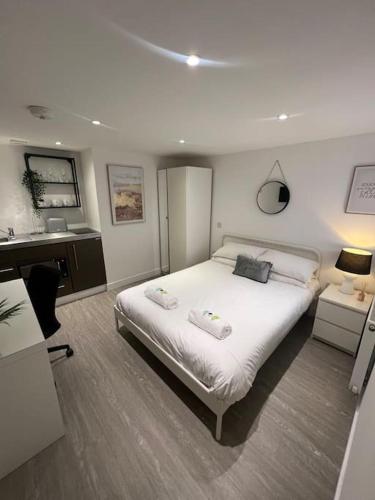 a bedroom with a bed with two towels on it at 2 Studio flat, 50m from Airbus in Bristol
