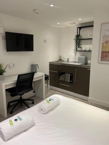 a bedroom with a desk and a bed with two towels at 2 Studio flat, 50m from Airbus in Bristol