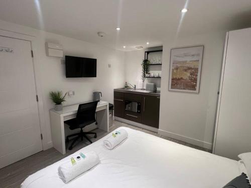 a bedroom with a bed and a desk with a computer at 2 Studio flat, 50m from Airbus in Bristol