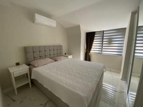 Retro 15 3+1 في ألانيا: غرفة نوم بيضاء بها سرير ونافذة