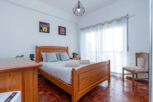 a bedroom with a bed and a desk and a window at Bella Vista - Vue Océan in Buarcos