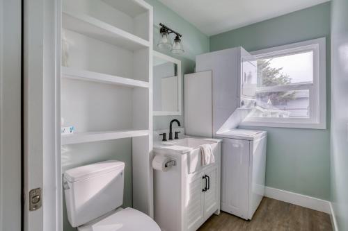 a white bathroom with a toilet and a sink at Gardner Family House #1 in Depoe Bay