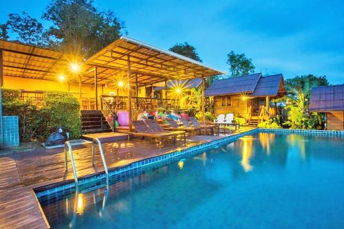 a swimming pool in front of a house at The Cobble Beach - SHA Certified Vaccinated in Phi Phi Islands