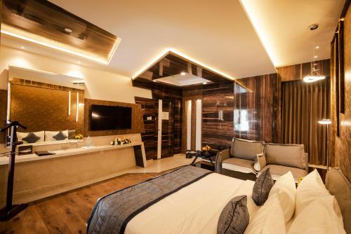 a hotel room with a bed and a bathroom at Hotel Park Elanza Coimbatore in Coimbatore