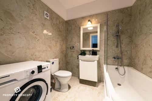a bathroom with a toilet and a sink and a washing machine at Central Residence Apartment 505 in Bucharest