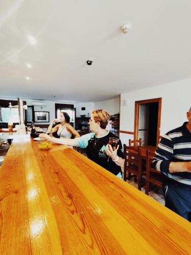 a group of people standing around a wooden table at Posada de Ollo in Ollo