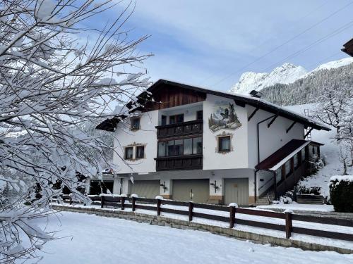 a building with a fence in the snow at Haus Anna in Sankt Anton am Arlberg