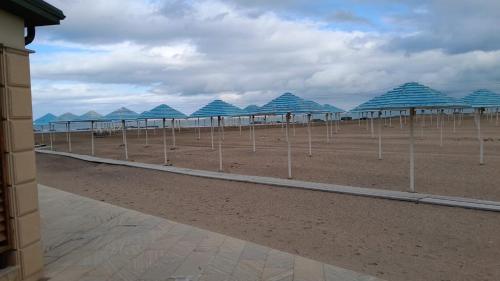 una fila de sombrillas azules en la playa en All breeze, en Shagan