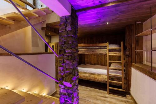 a room with bunk beds and purple lighting at Superbe logement, jacuzzi extérieur, vue, sauna in Champagny-en-Vanoise