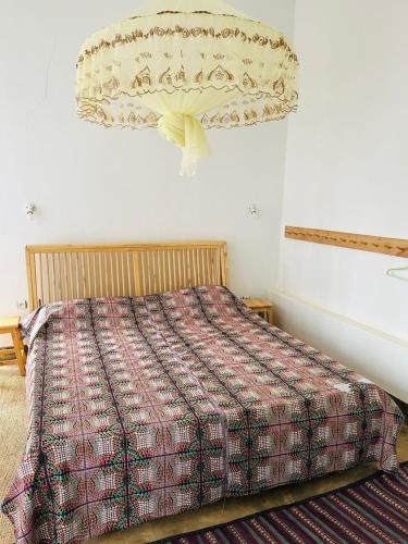 a bedroom with a bed with a comforter at Isange Paradise Resort in Ruhengeri