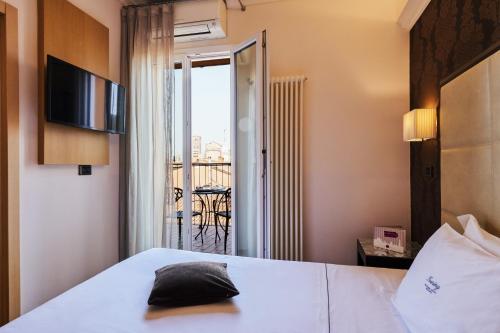a hotel room with a bed and a balcony at Hotel Touring in Bologna
