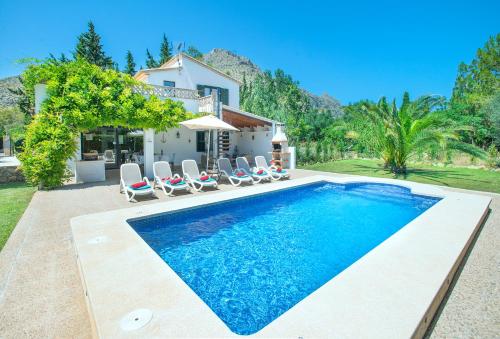 a swimming pool with chairs and a house at Owl Booking Villa Bocoris - 15 Min Walk to the Beach in Port de Pollensa