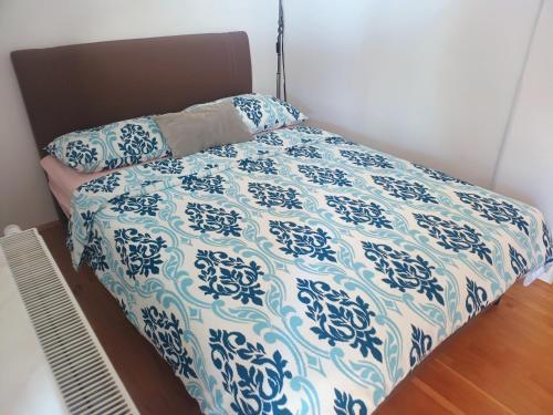 a bed with a blue and white comforter at Apartman Kiss in Osijek