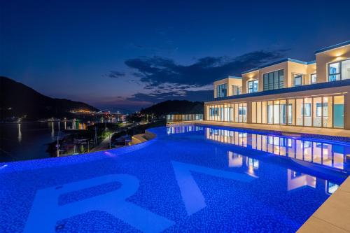 a swimming pool in front of a building at night at Yeosu Blueara Premium Pool Villa in Yeosu