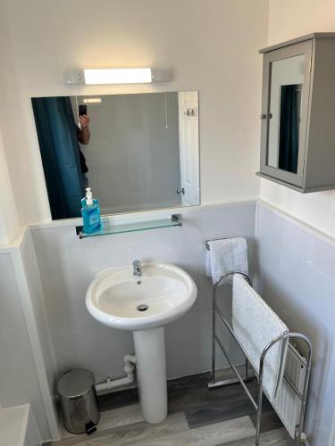 y baño con lavabo y espejo. en SeaCross Sheringham Norfolk Coast 3 Bed Detached house en Sheringham