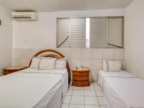 a bedroom with two beds and a window at Hotel Itajubá Classic - Goiânia in Goiânia