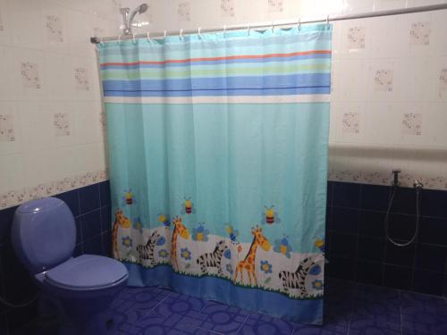 a bathroom with a shower curtain with animals on it at Pournami Home Stay in Trichūr