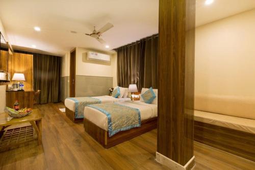 a hotel room with two beds and a table at OPO Viva Palace,Free Airport Pick-up in New Delhi