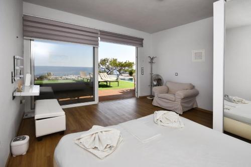 a bedroom with a bed and a view of the ocean at ocean Island villa Achlia in Ierapetra