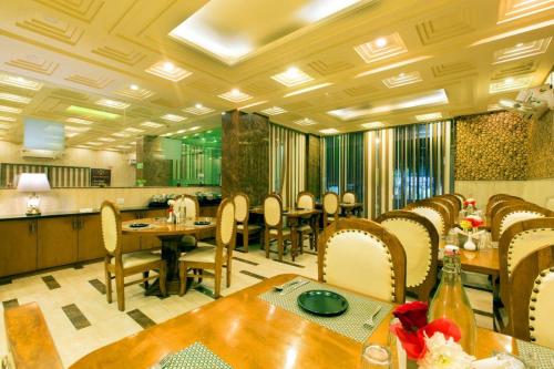 OPO Hotel Viva Palace في نيودلهي: غرفة طعام مع طاولات وكراسي ومطبخ
