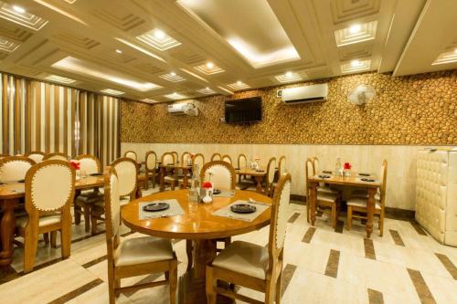 a restaurant with wooden tables and chairs in a room at OPO Viva Palace,Free Airport Pick-up in New Delhi