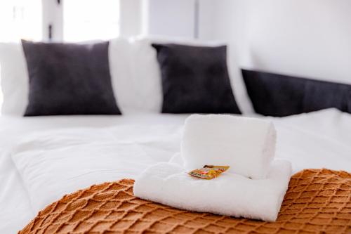 a white towel sitting on top of a bed at Highlight am Stadtplatz Mühldorf - C4S COME4STAY - 2 Zimmer Wohnung I bis zu 5 Gäste in Mühldorf