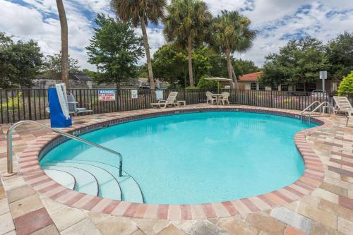 a large swimming pool in a yard with two chairs at Days Inn by Wyndham Sarasota I-75 in Sarasota