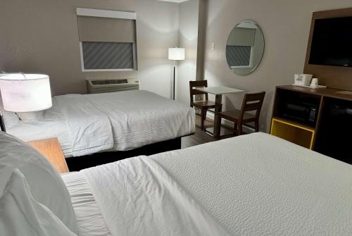 a hotel room with two beds and a table at Days Inn by Wyndham Sarasota I-75 in Sarasota