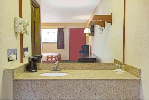 a bathroom with a sink in a hotel room at Super 8 by Wyndham Cincinnati-Springdale OH in Springdale