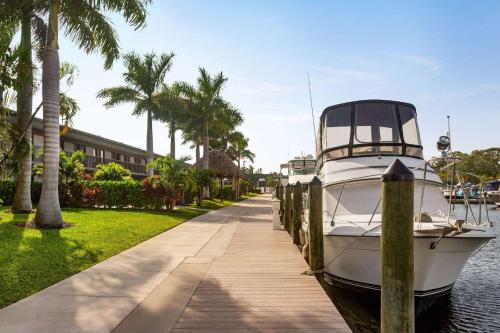 薩拉索塔的住宿－Ramada by Wyndham Sarasota Waterfront，停靠在房子旁边的码头的船只