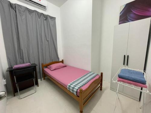 a small bedroom with a bed and a cabinet at Homestay Merbau Changloon in Changlun